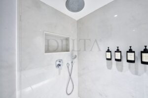 Beyaz Calacatta mermer kaplı, duvara monte modern lavabolu , duşlu lüks mermer banyo tasarımı.